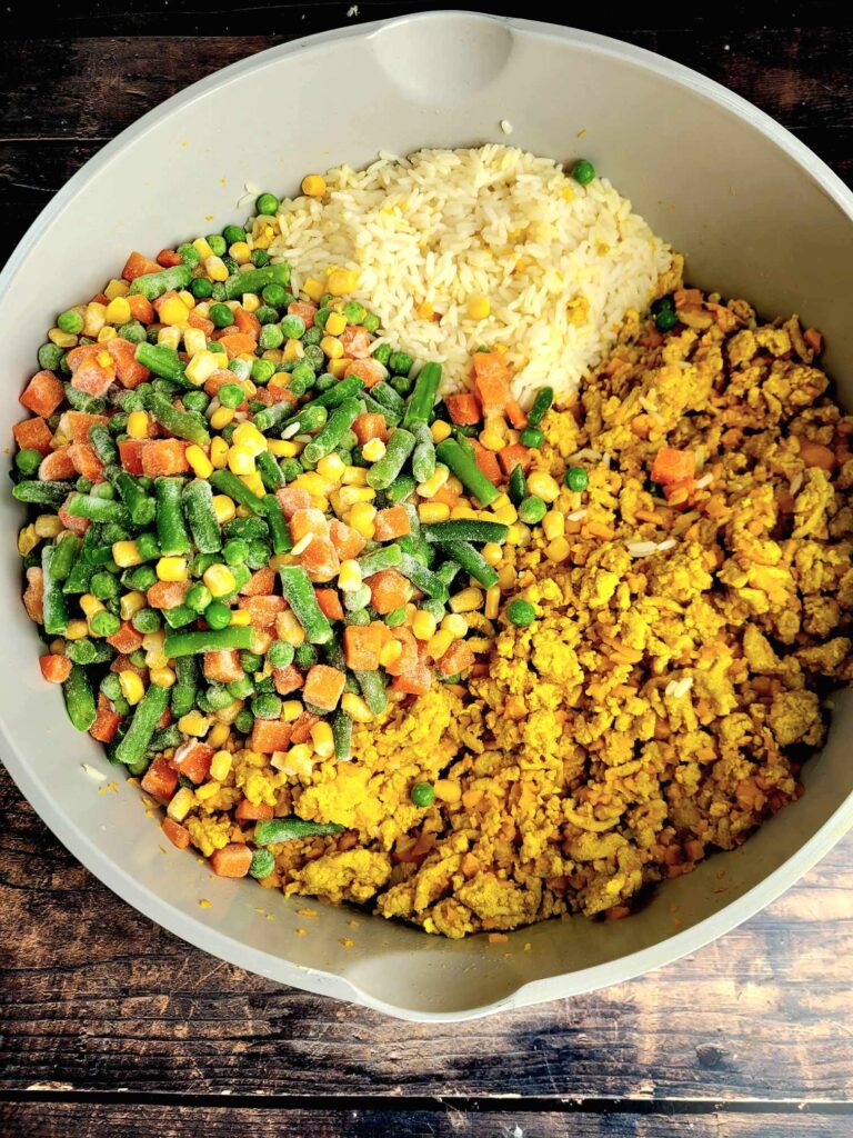 boiled rice, ground chicken and mixed veggies in a large pot making diy homemade dog food