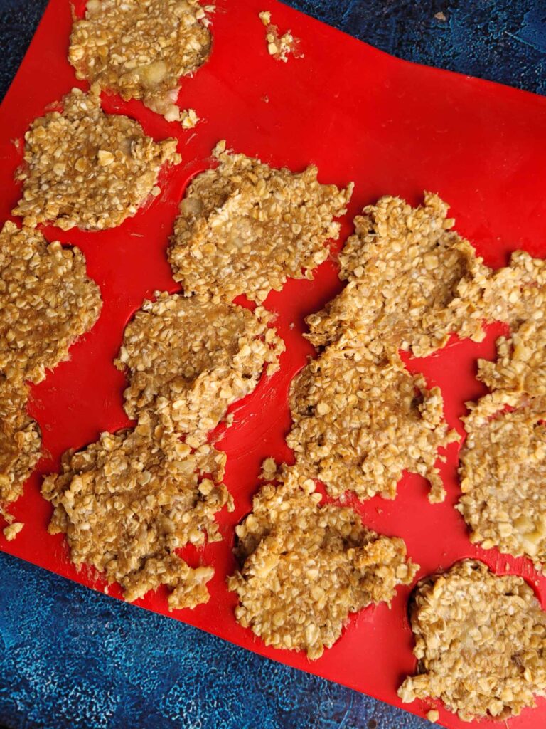 adding peanut butter banana dog biscuit batter to the paw print molds