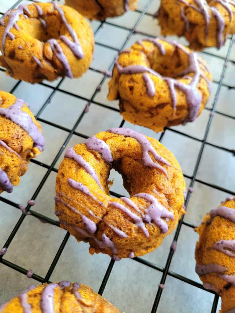 Easy baked dog donuts that are festive dog treats for Halloween, all-natural dog donuts, and perfect dog-friendly fall desserts. Quick, spooky, and fun Halloween dog treat recipe your pups will love!