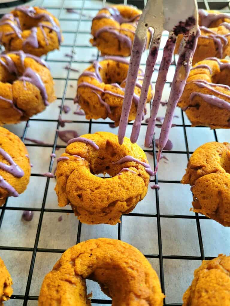 adding blueberry drizzle to baked pumpkin mini donuts for dogs